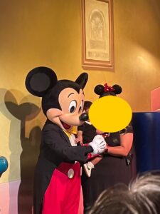 カリフォルニアディズニーランドにてゲストと写真撮影をするミッキー